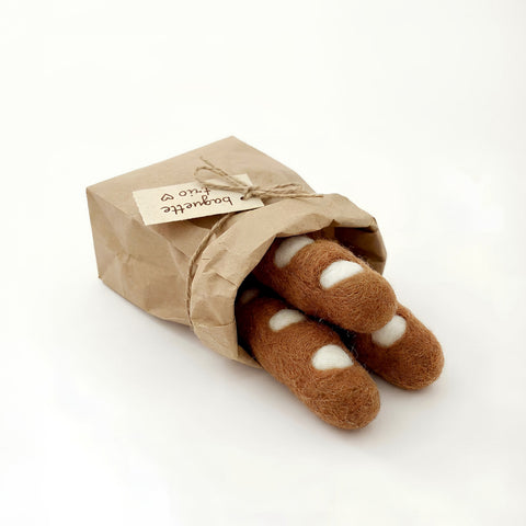 Felt baguettes spilling out of paper bag