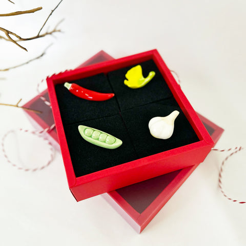 4 utensil rests posed on a red box with black padding